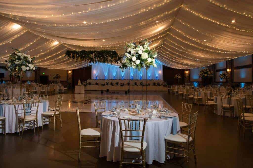 Elegant wedding reception hall with white draping and fairy lights.