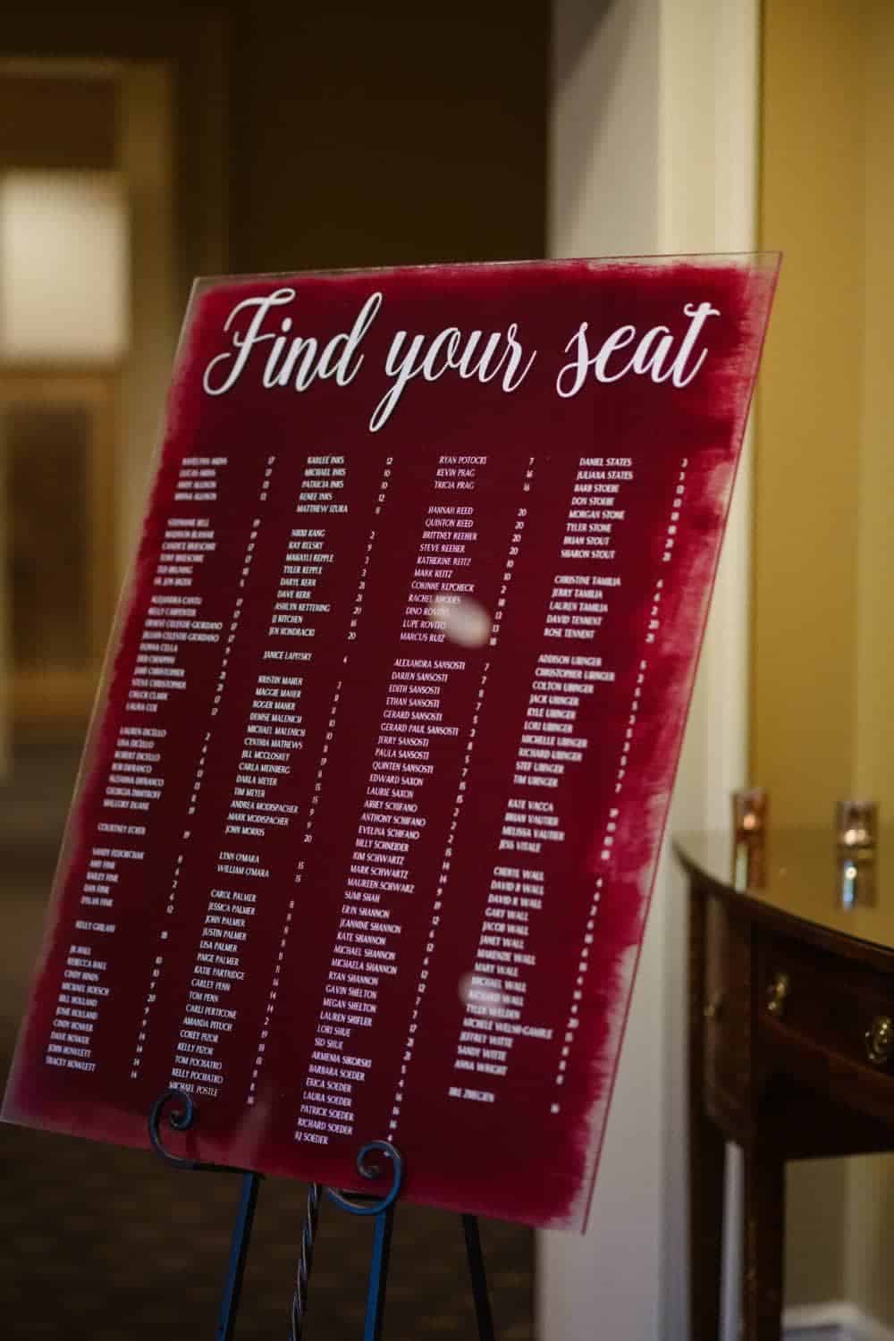 Modern acrylic wedding seating chart with custom brush-stroke paint detail and gold hardware by ILLUME in Pittsburgh.
