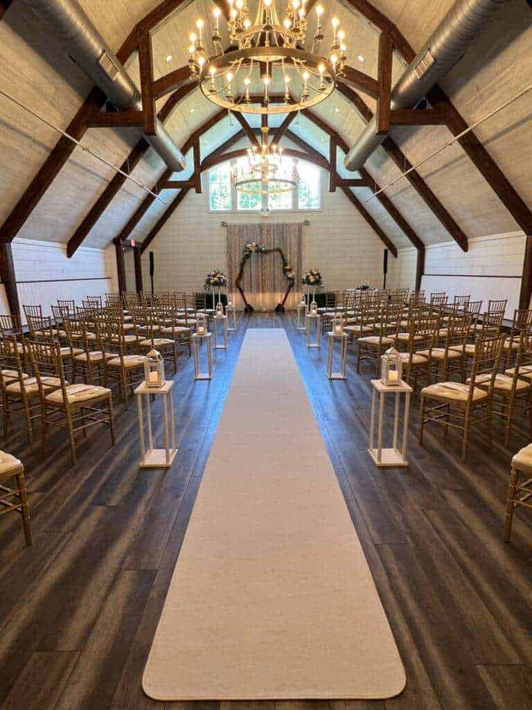 Elegant indoor ceremony decor and fabric draping by ILLUME at The Stables at Connoquenessing in Renfrew, PA.