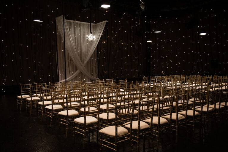 Dramatic wedding ceremony backdrop with luxury chandeliers and custom lighting by ILLUME at WQED Studios in Oakland, Pittsburgh.