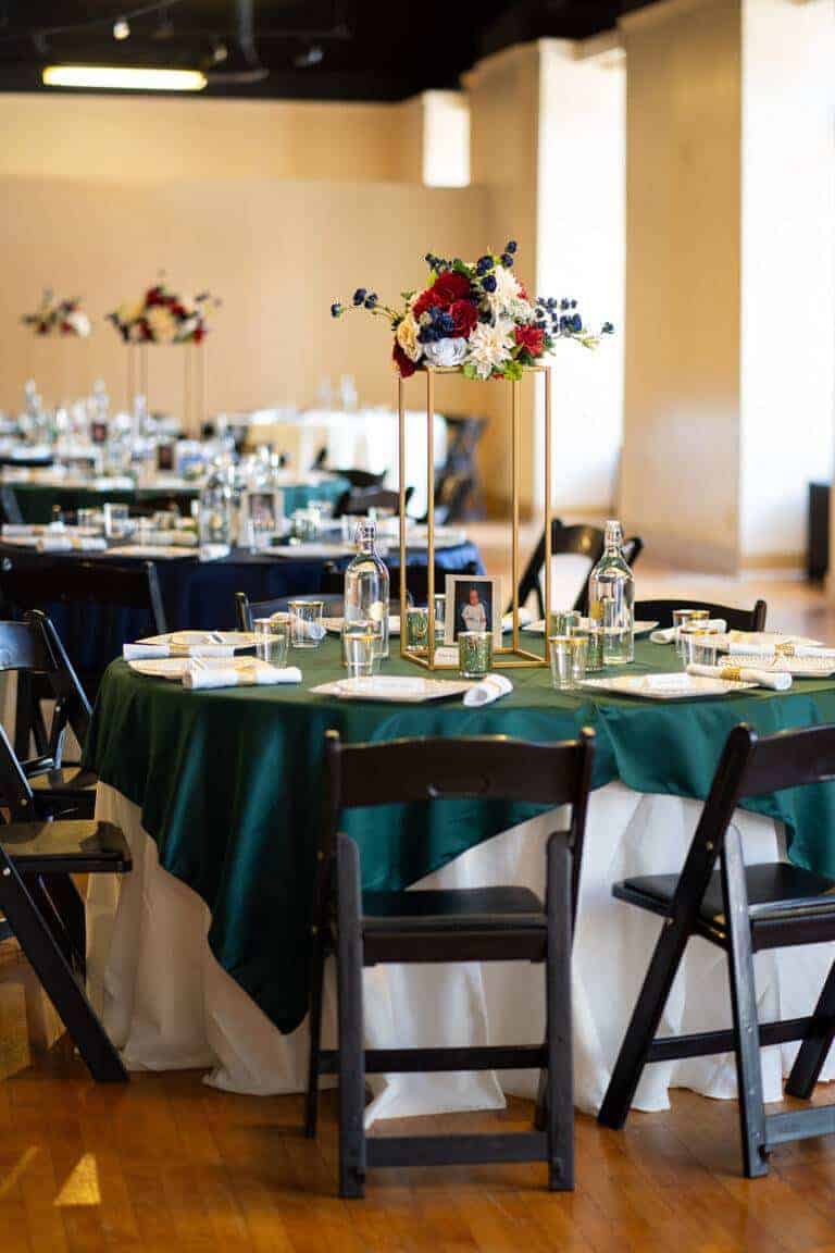 Elegant elevated floral centerpiece on a tall gold pedestal stand by ILLUME, featuring white hydrangeas and roses for a luxury ballroom wedding.