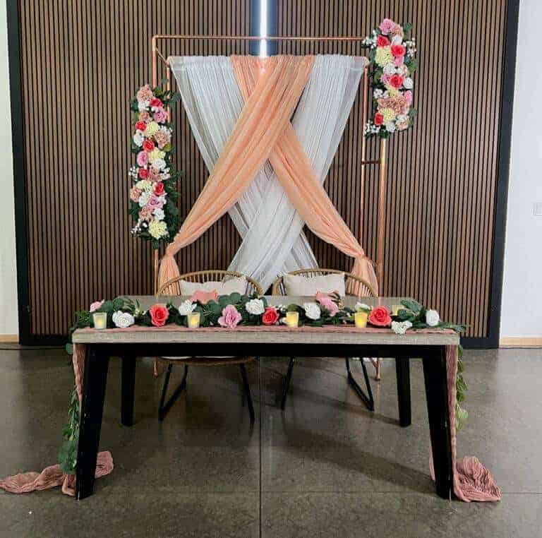 Modern copper ceremony arch with romantic white draping by ILLUME at The Harper Event Venue in Meadville, PA.